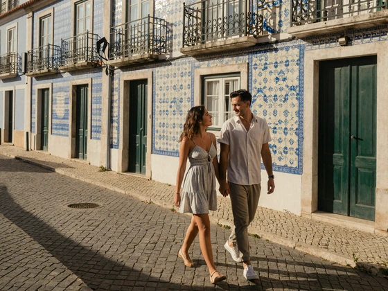 Couple walking through the historic Alfama district of Lisbon with traditional azulejo tiles